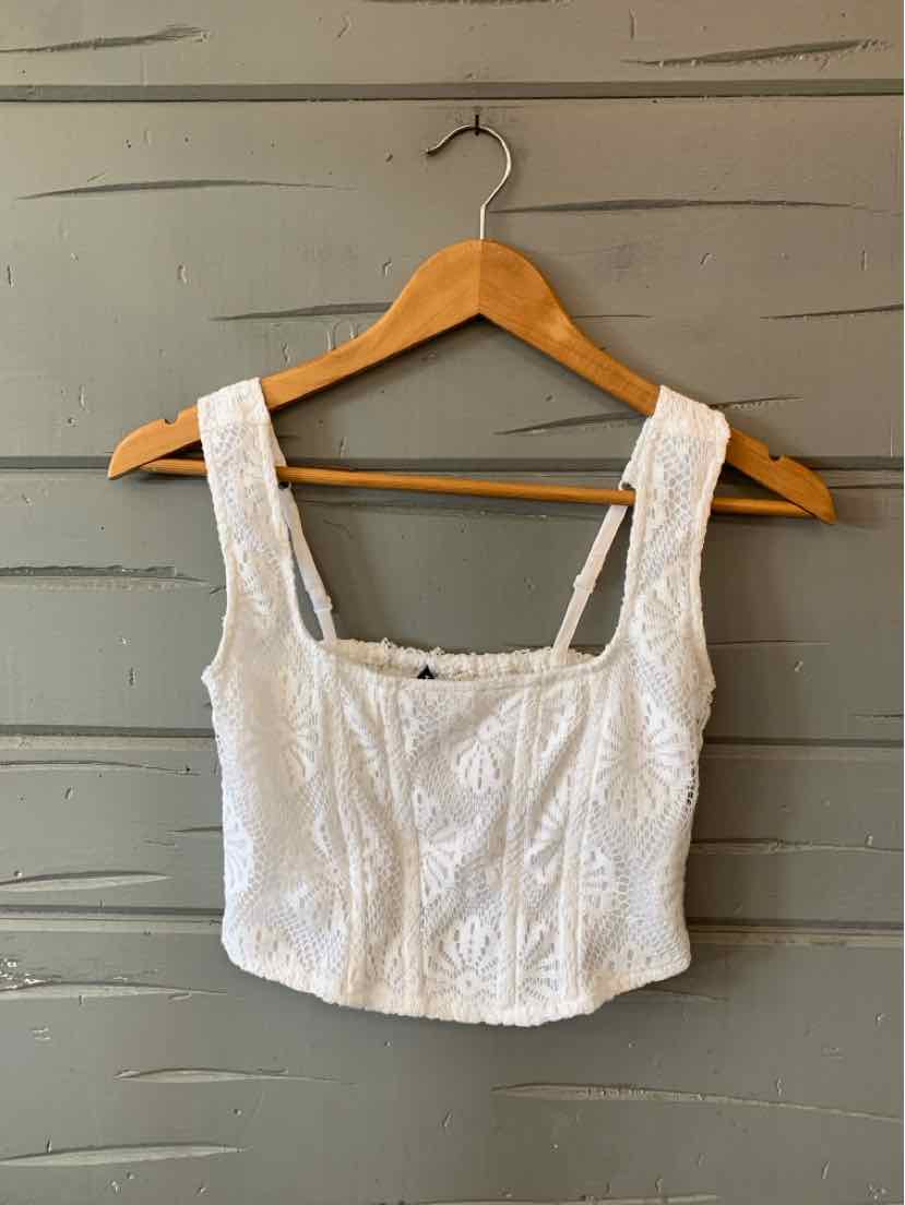 White lace crop top with square neckline and wide straps on wooden hanger.