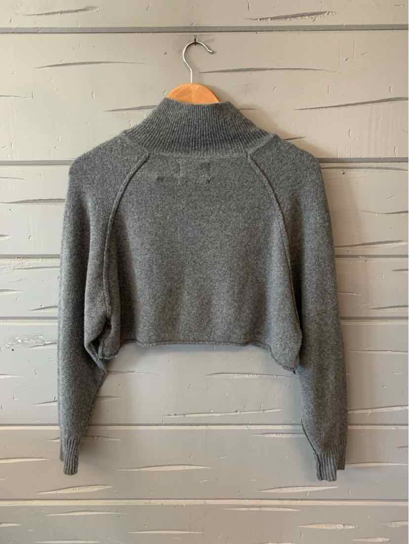 Gray cropped long-sleeve sweater with mock neck and ribbed cuffs hanging on wooden hanger.