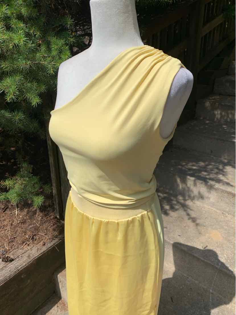 Soft yellow sleeveless one-shoulder top with ruched detailing and fitted waist.