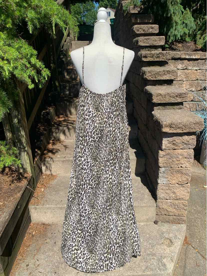 Long leopard print slip dress with thin black spaghetti straps and a loose, flowing fit.