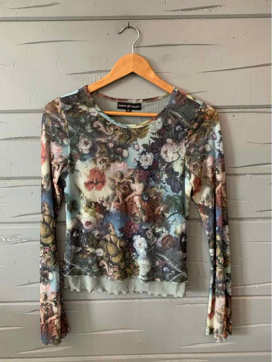 Long-sleeve fitted floral top in muted pastel colors with a scoop neckline and sheer fabric.