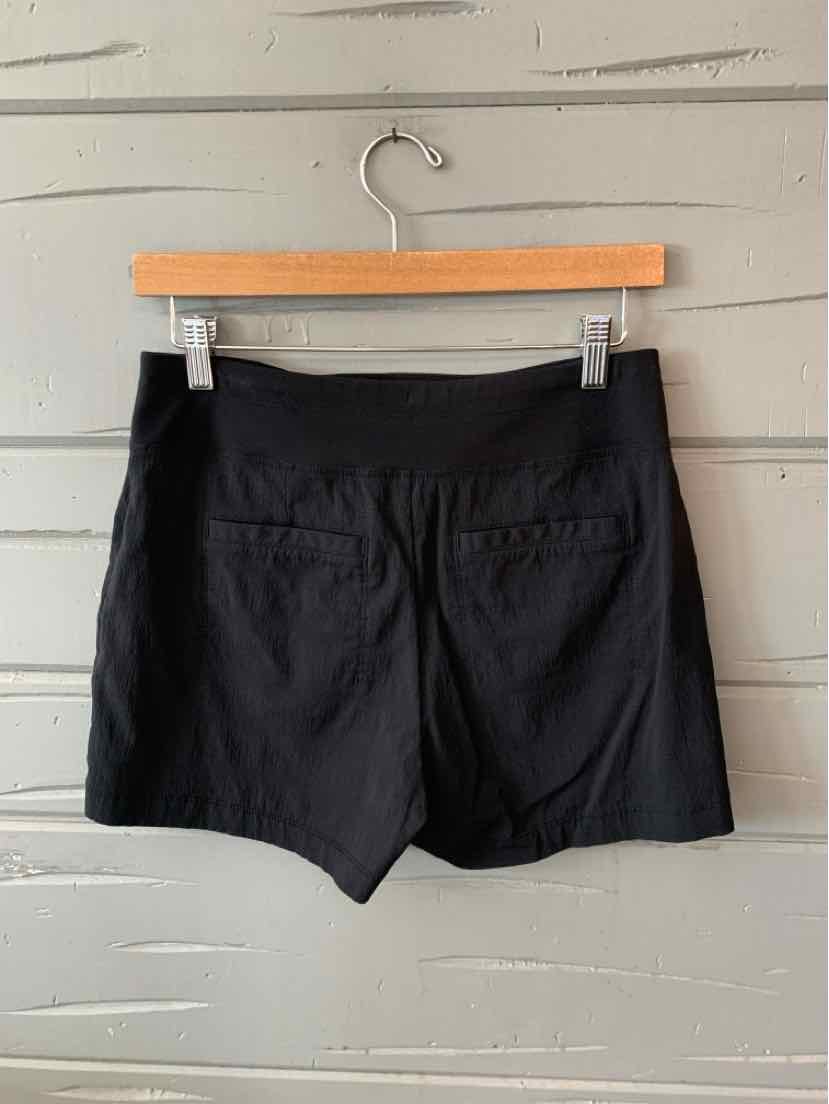 Black athletic shorts in size 2 with a smooth waistband and back pockets hanging on a wooden hanger.