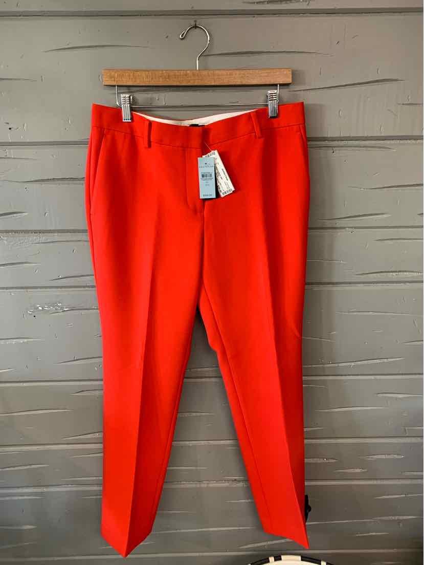 Bright red tailored women's trousers in size 10P with belt loops and front pockets, hanging on wooden hanger.