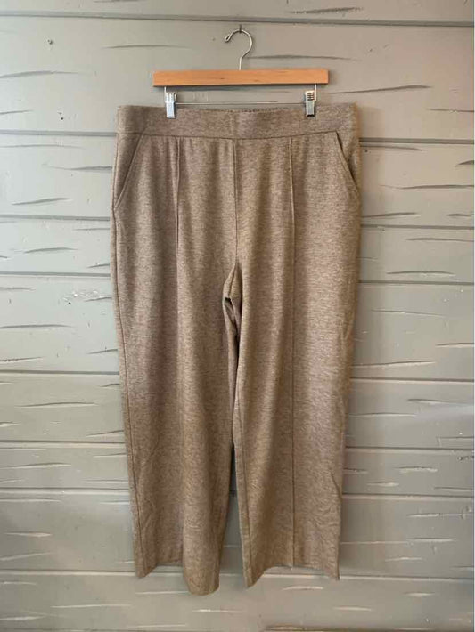 Beige wide-leg pants with elastic waistband and side pockets in soft knit fabric.