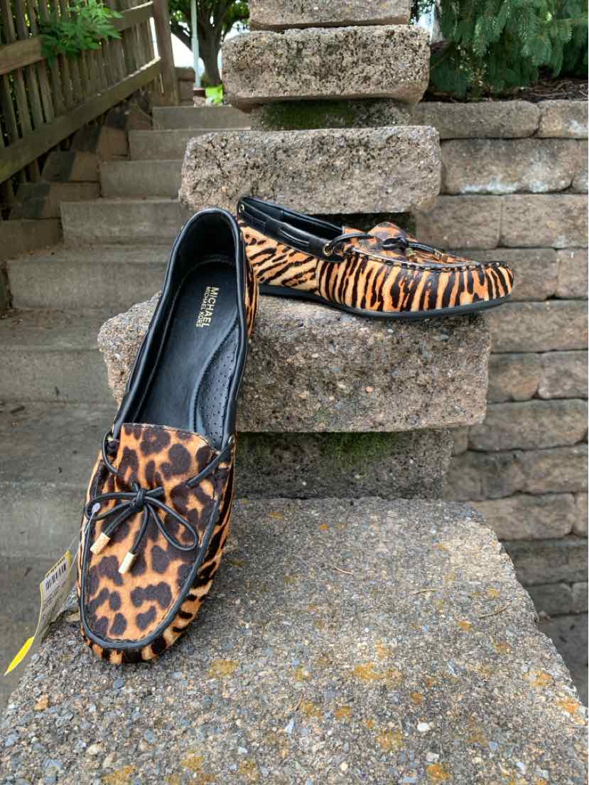 Women’s size 11 Michael Kors tan slip-on loafers with cheetah print and black trim.