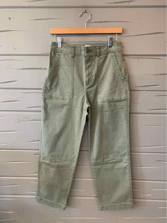 Olive green Gap cargo pants with a straight-leg fit, button closure, and large side pockets, hanging from a wooden hanger.