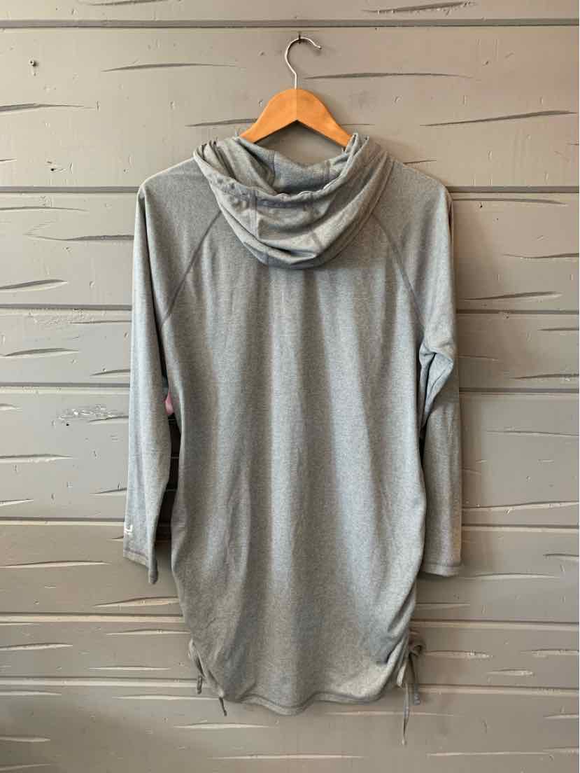 Light gray long-sleeve hoodie dress with relaxed fit and cinched hem on wooden hanger against gray wood background.