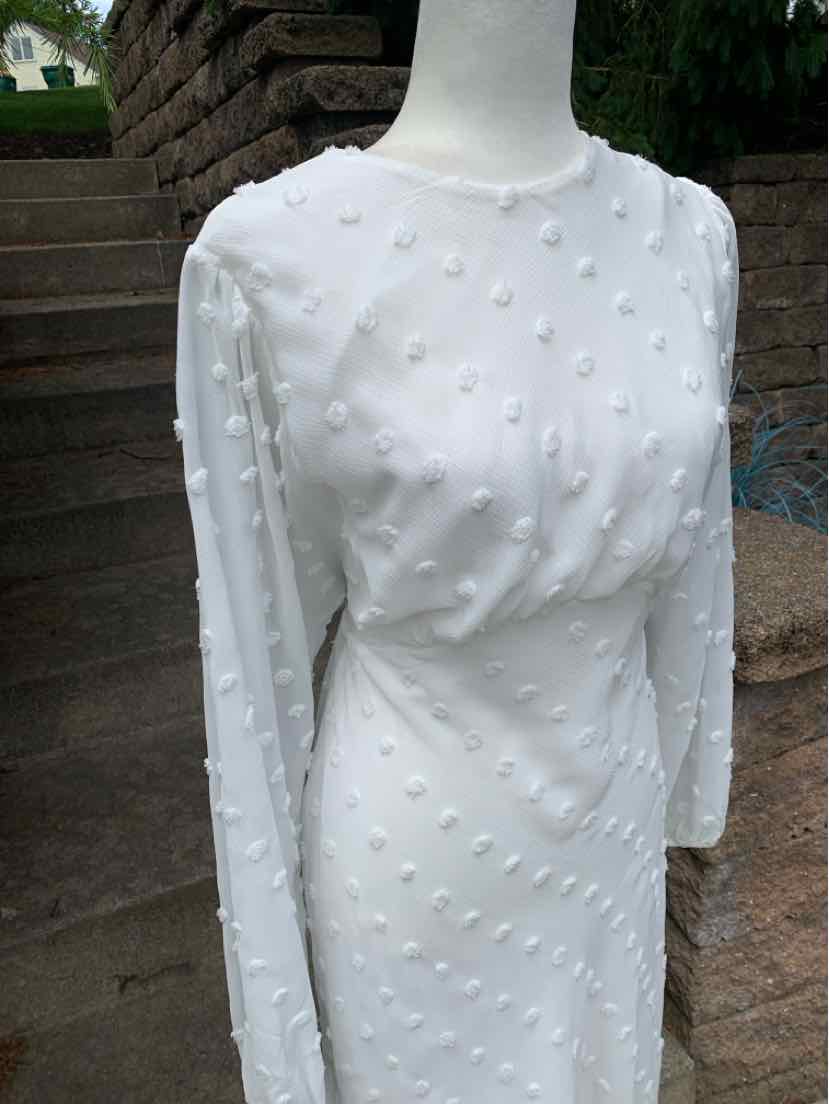 White long-sleeve midi dress with raised textured dot pattern and fitted waist.