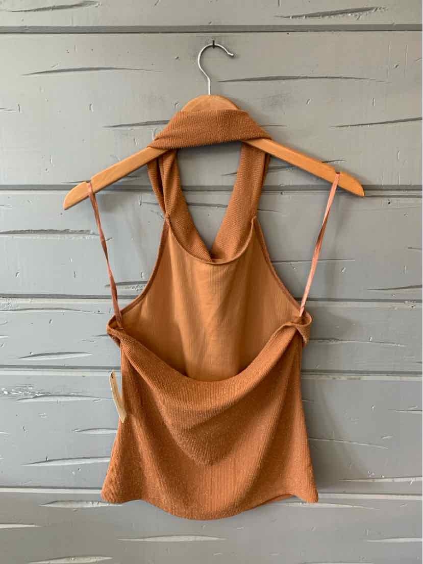 Tan sleeveless tank top with wide straps and a scooped neckline hanging on a wooden hanger against a gray wood background.