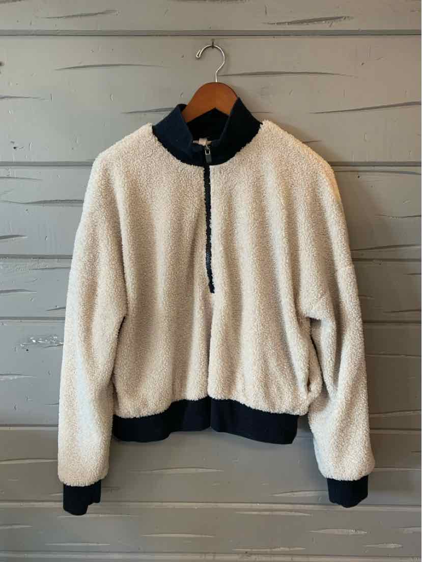 Cream Fabletics fleece jacket with black stand collar, quarter zip, and ribbed cuffs and hem.