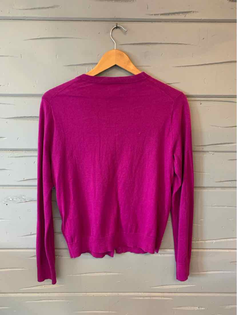 Bright magenta long-sleeve lightweight crewneck sweater hanging on wooden hanger.