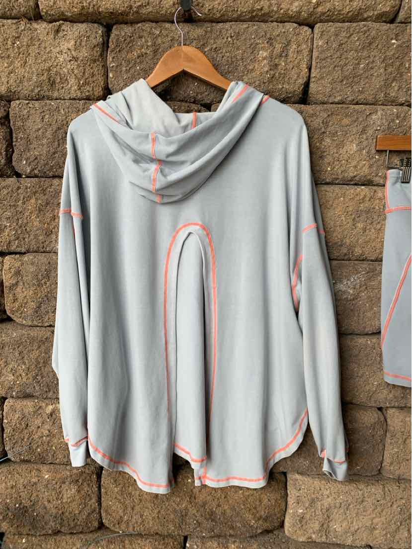 Light gray hooded long-sleeve top with loose fit and pink seam detailing.