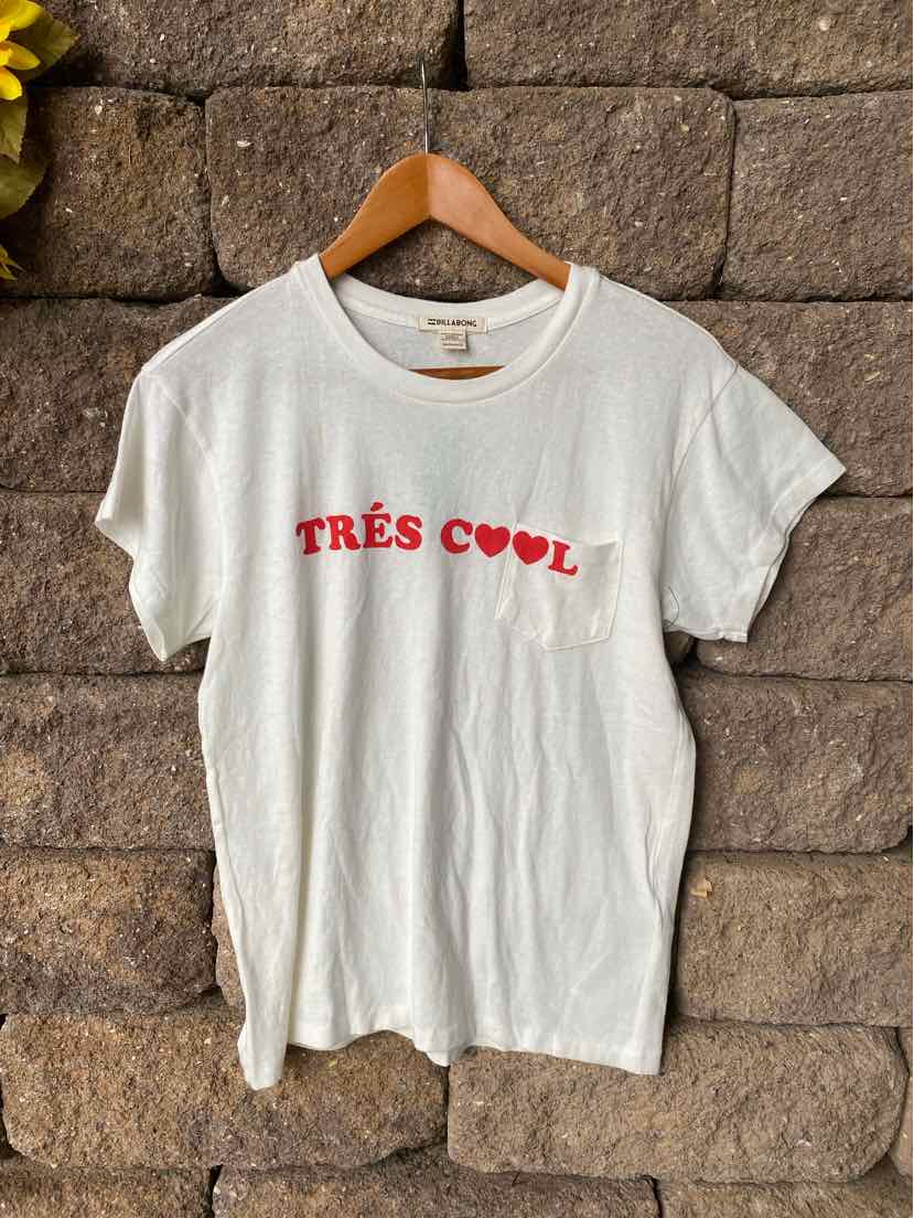 White cotton short-sleeve t-shirt with red "TRÈS COOL" text and small chest pocket.