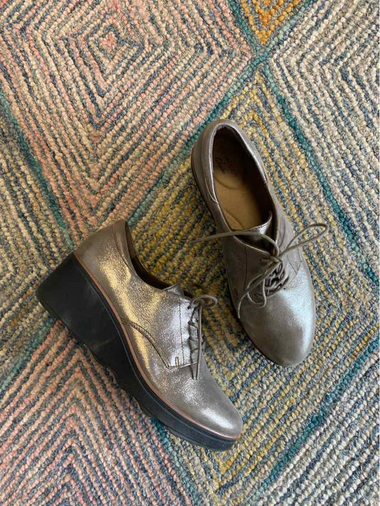Metallic silver leather lace-up shoes with rounded toes and thick black soles, size 10.