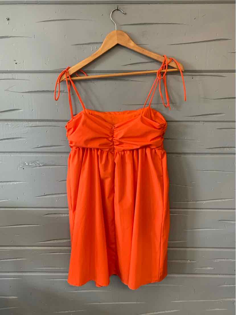 Orange sleeveless dress with ruched bust and tie straps, knee-length, lightweight fabric.