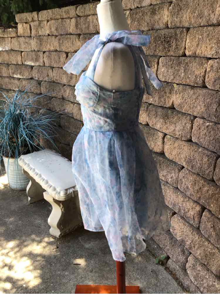 Light blue floral print sleeveless dress with fitted bodice and flowy layered skirt on mannequin.