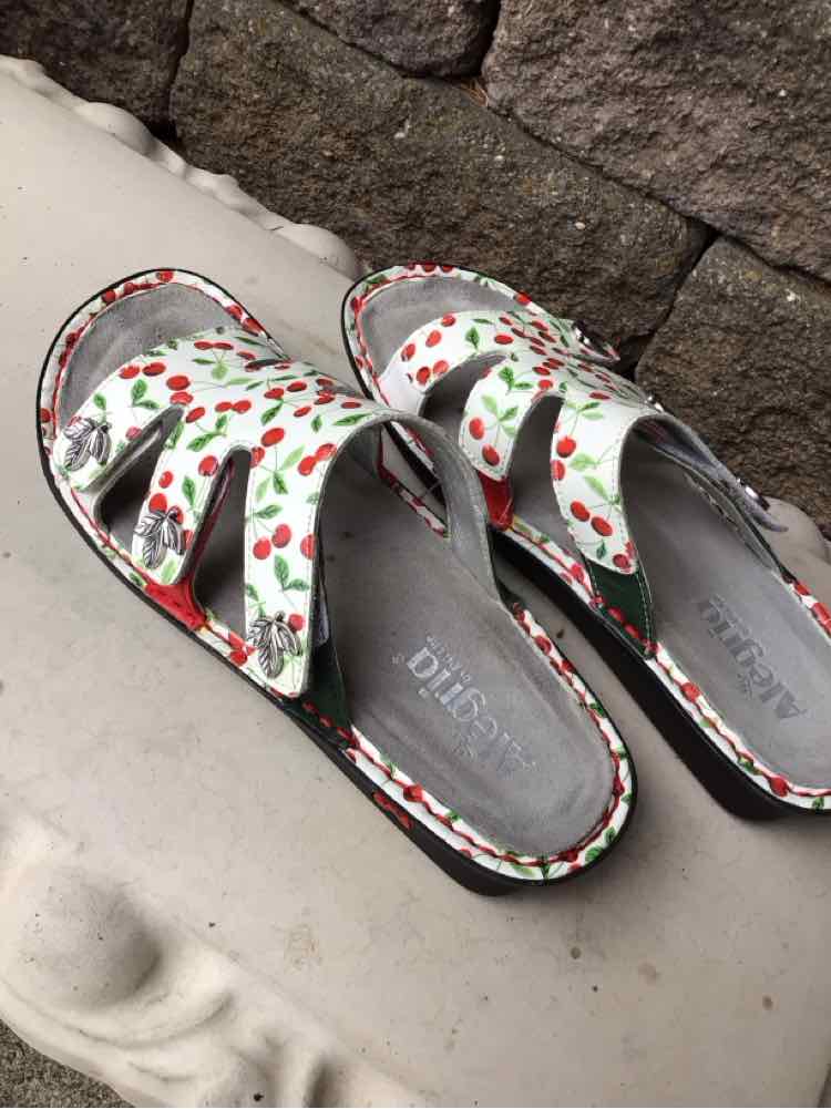 White sandals with red cherry print, adjustable velcro straps, and cushioned footbed in size 39.