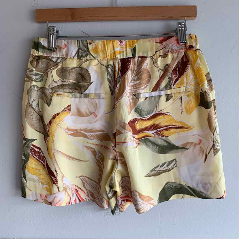 Yellow tropical print shorts with elastic waistband and back welt pockets.