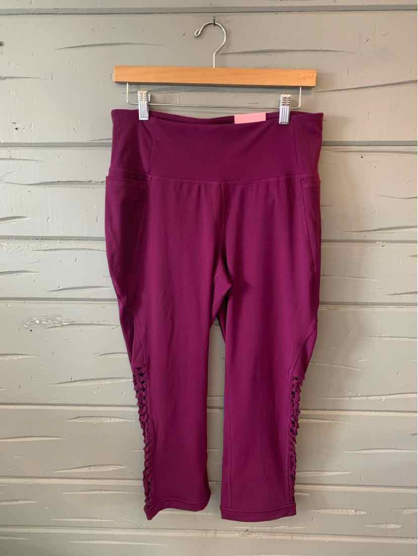 Plum-colored cropped leggings with high waist and mesh panel accents on lower legs.