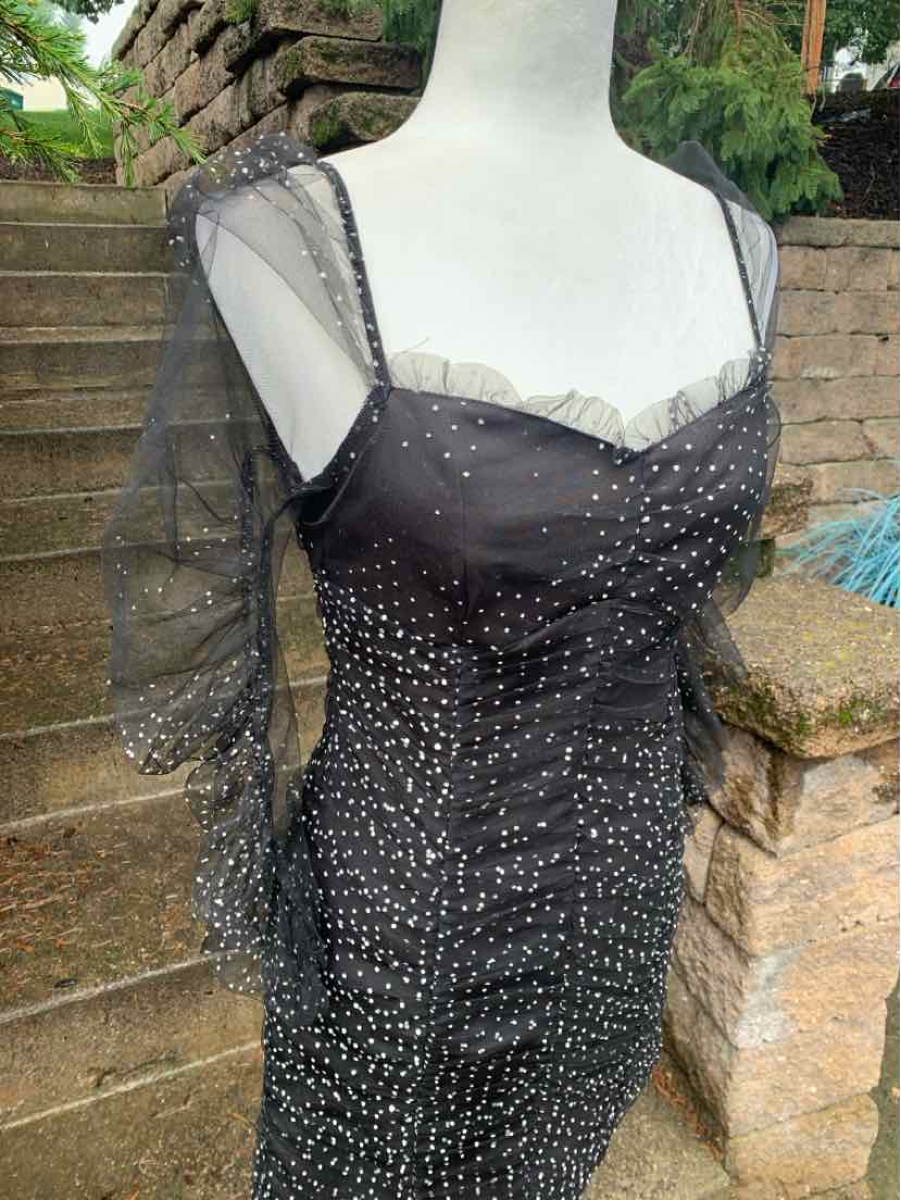 Black sheer dress with polka dots, ruched bodice, square neckline, and puff sleeves.