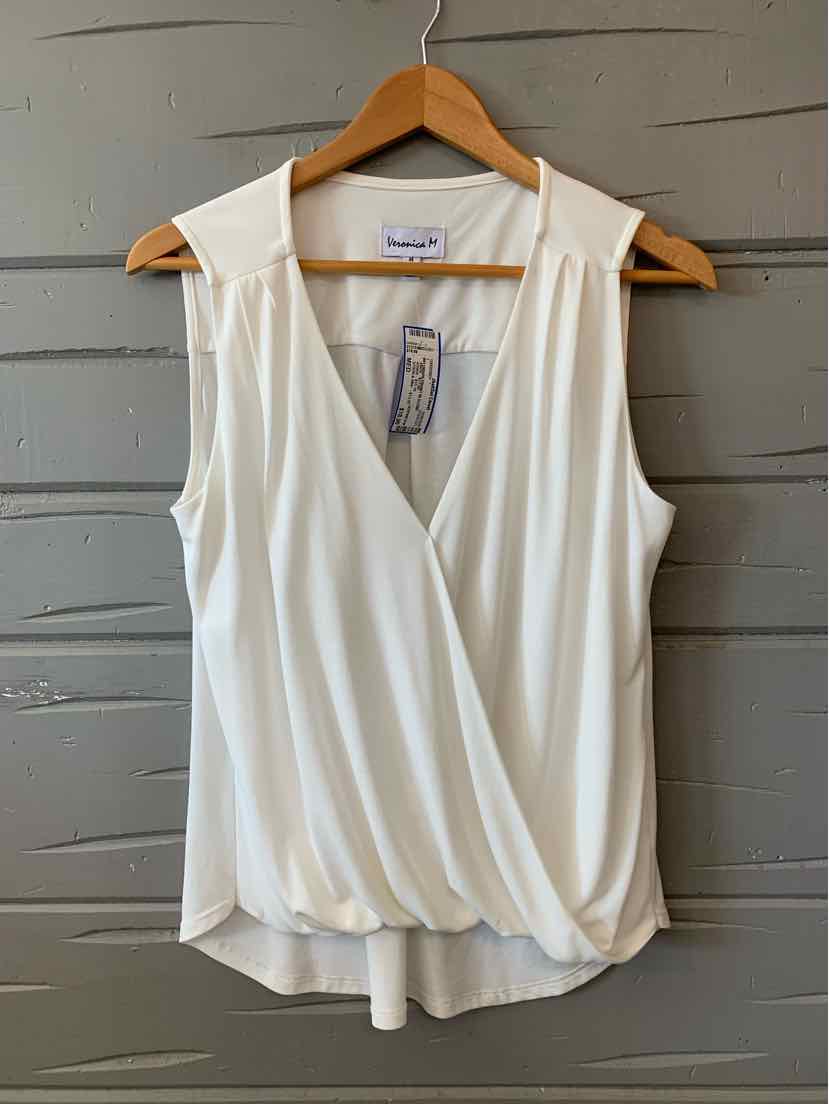 White sleeveless blouse with wrap-style front and soft draping, medium size hanging on wooden hanger.