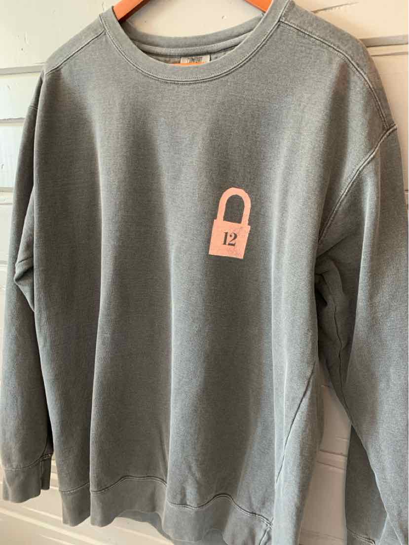 Dark gray long-sleeve crewneck sweatshirt with pink lock graphic and soft cotton fabric.
