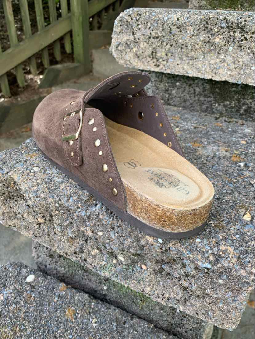 Brown suede studded clog with a tan cork-style sole and open back.