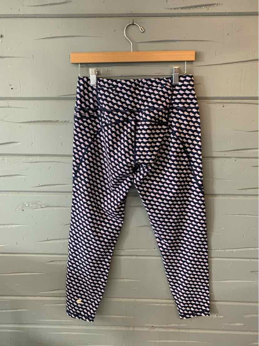 Black and white patterned cropped leggings with flat waistband, medium size, hanging on wooden hanger.