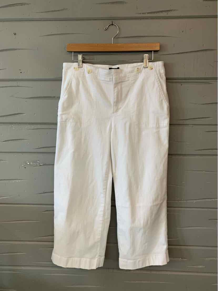 White wide-leg cropped pants with front pockets and belt loops on a wooden hanger.