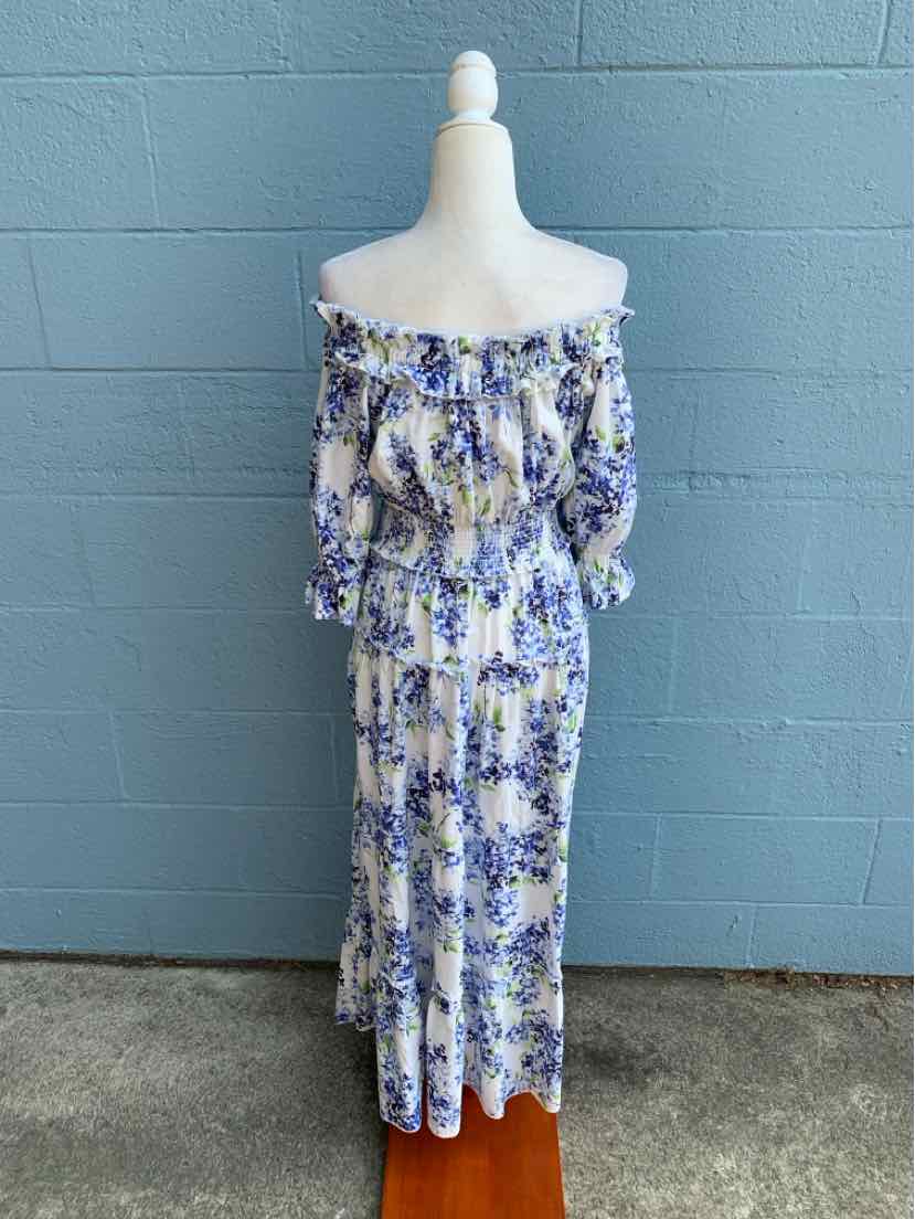 Off-the-shoulder blue and white floral maxi dress with smocked bodice and long sleeves.