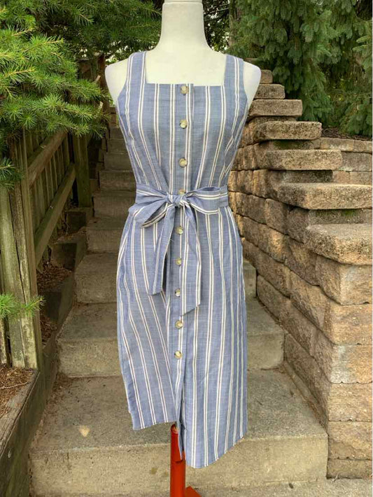 Sleeveless blue midi dress with white vertical stripes, square neckline, front buttons, and waist tie belt.