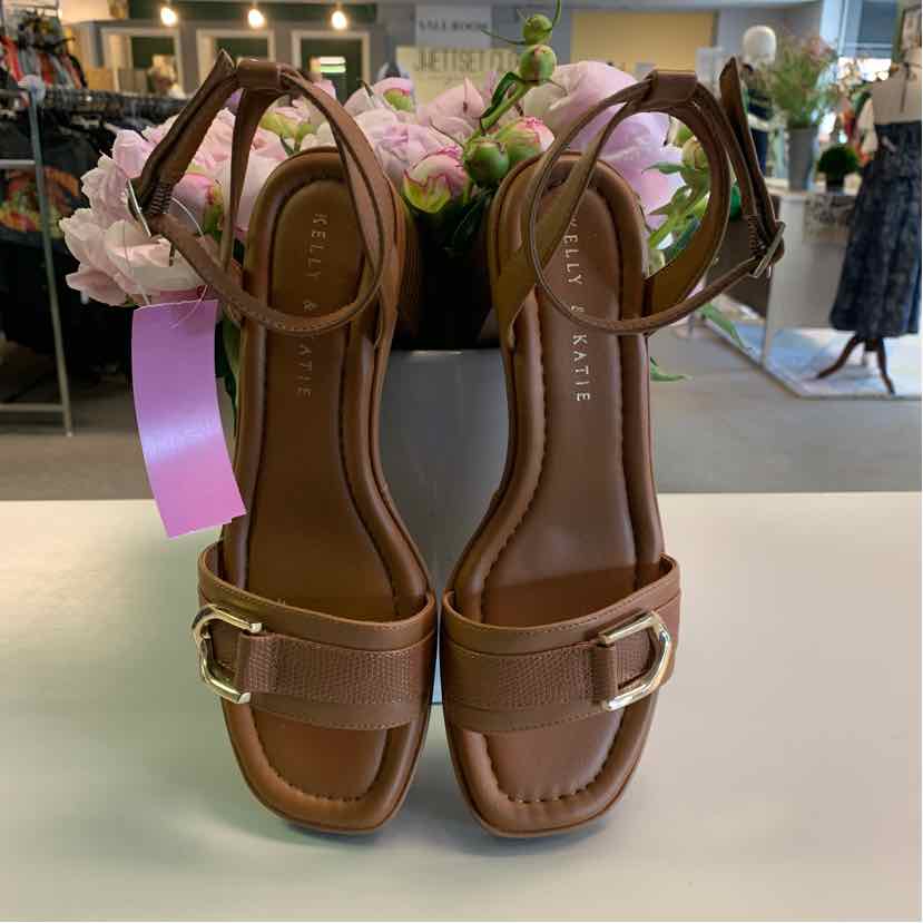 Tan leather flat sandals with adjustable ankle straps and square gold buckle accents, size 8.5.