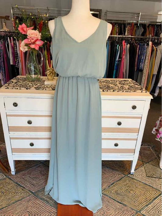 Light green sleeveless maxi dress with V-neck and gathered waist on mannequin.