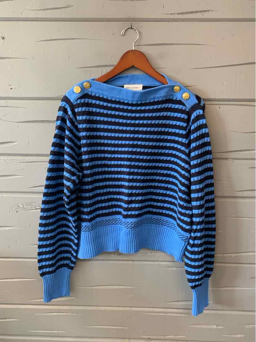 Blue striped knit sweater with long sleeves, a wide ribbed hem, and button details at the shoulders, hanging on a wooden.