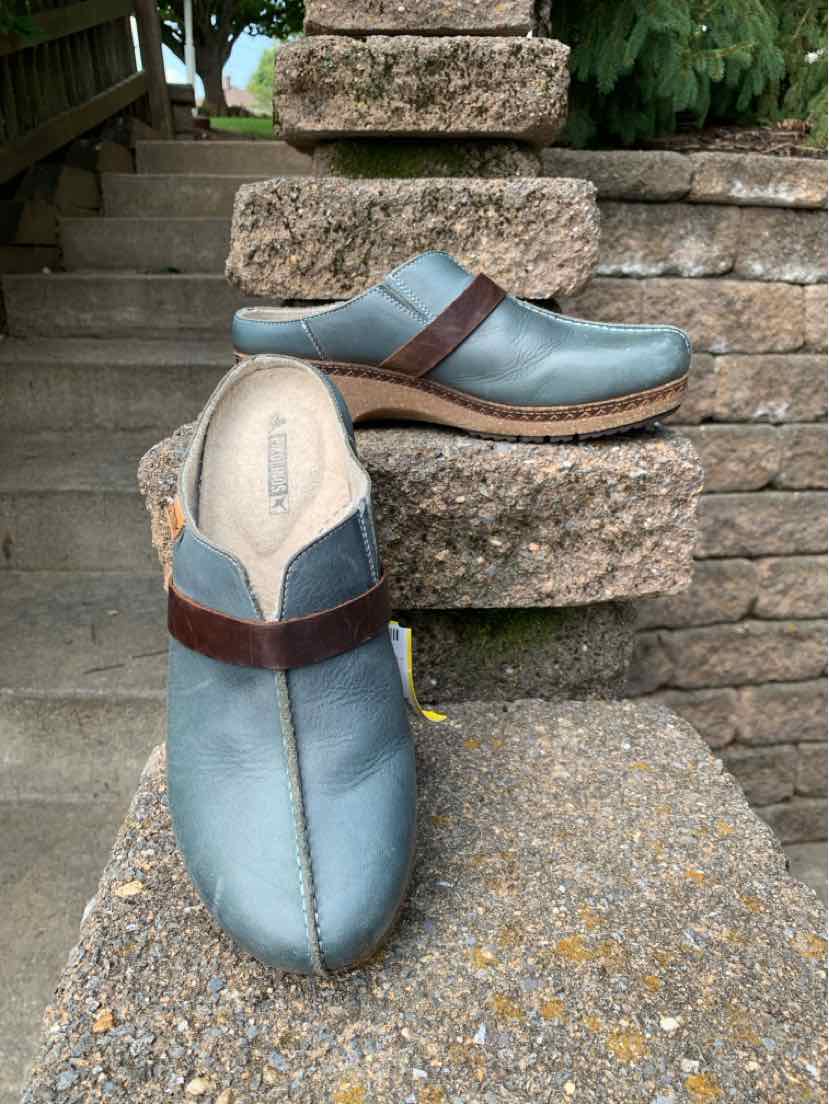 Light blue leather slip-on clogs with brown strap detail and cushioned sole, size 39.