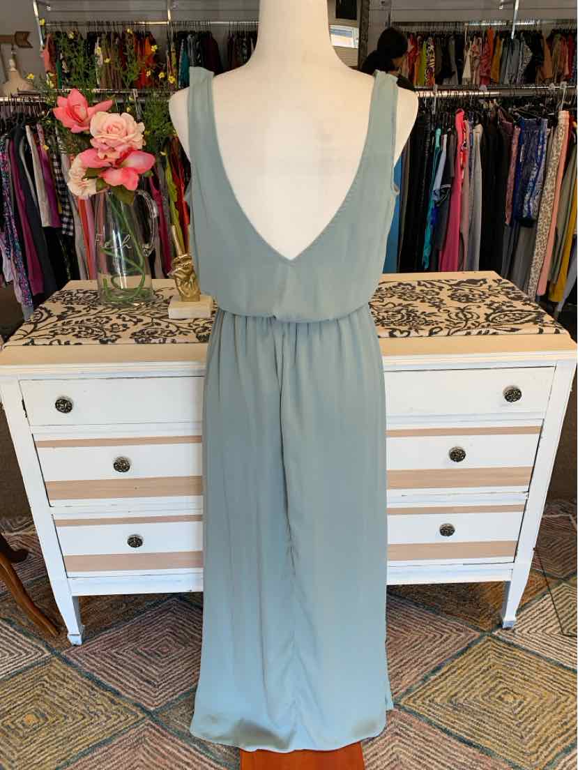 Sleeveless sage green maxi dress with deep V-neck and gathered waist on dress form.