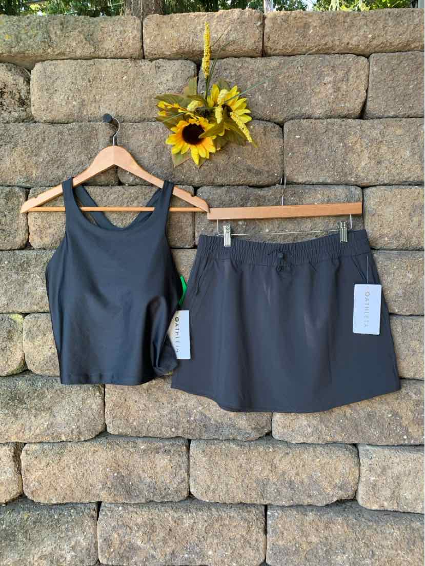 Charcoal gray sleeveless athletic tank with racerback and matching athletic skort with elastic waistband and front pockets.