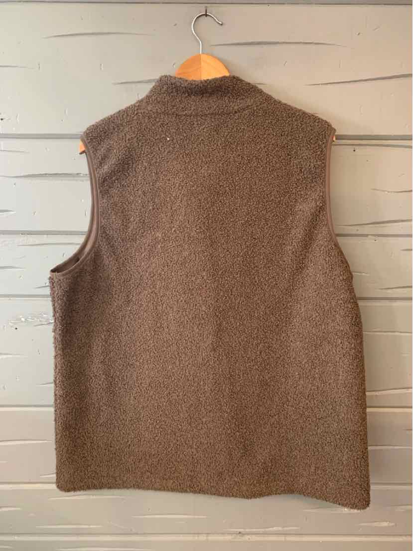 Beige sleeveless fleece vest with high collar and soft textured fabric in size XXL hanging on wooden hanger.