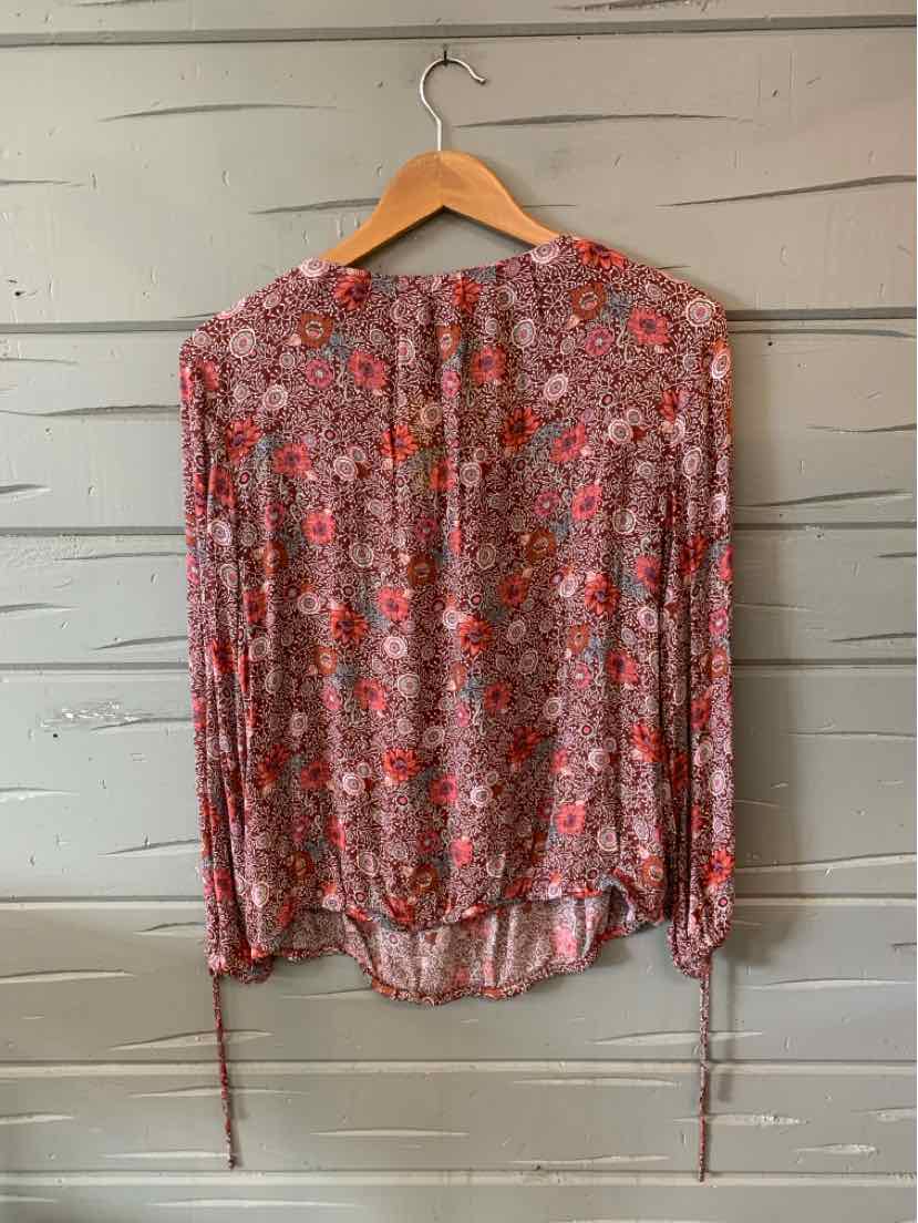 Long-sleeve red blouse with paisley and floral print, lightweight fabric, adjustable wrist ties.