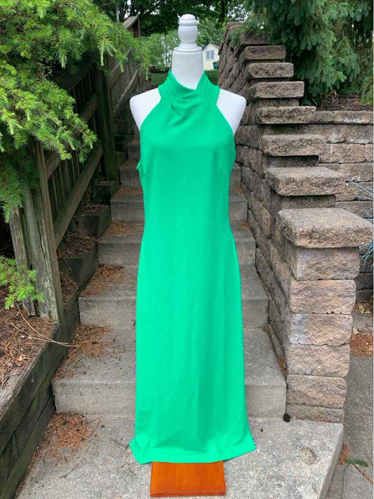 Sleeveless halter-neck bright green midi dress with a straight hem on mannequin outdoors.