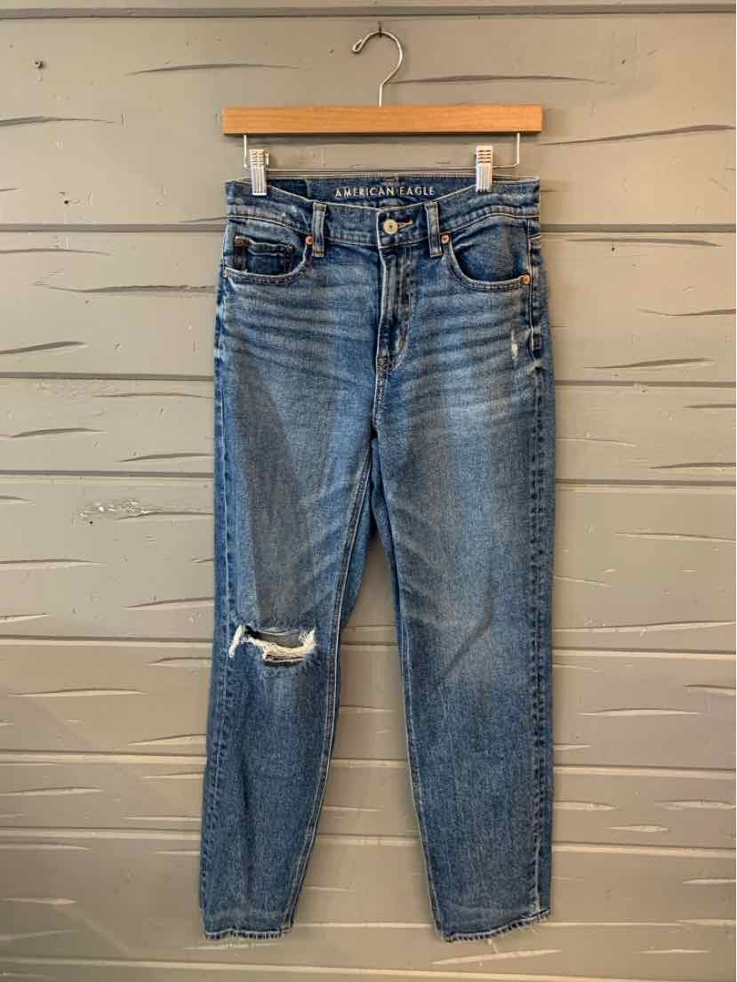 Blue denim jeans with a slim fit, distressed knee detail, and classic five-pocket design.