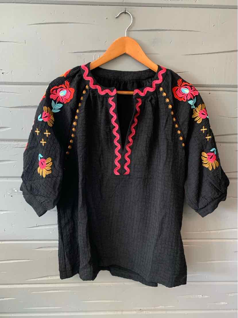 Black textured blouse with colorful floral embroidery on puffed sleeves and pink scalloped trim around neckline, size XL.