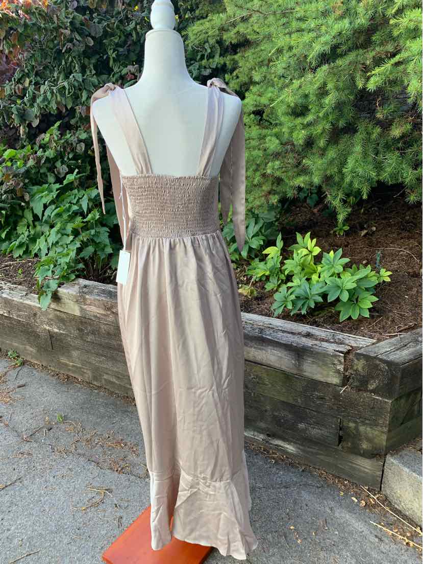 Beige sleeveless maxi dress with smocked bodice, wide straps, and ruffled hem.