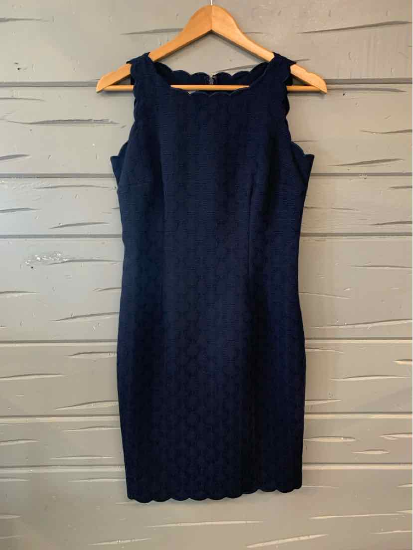 Navy blue sleeveless sheath dress with scalloped neckline and hem on wooden hanger.