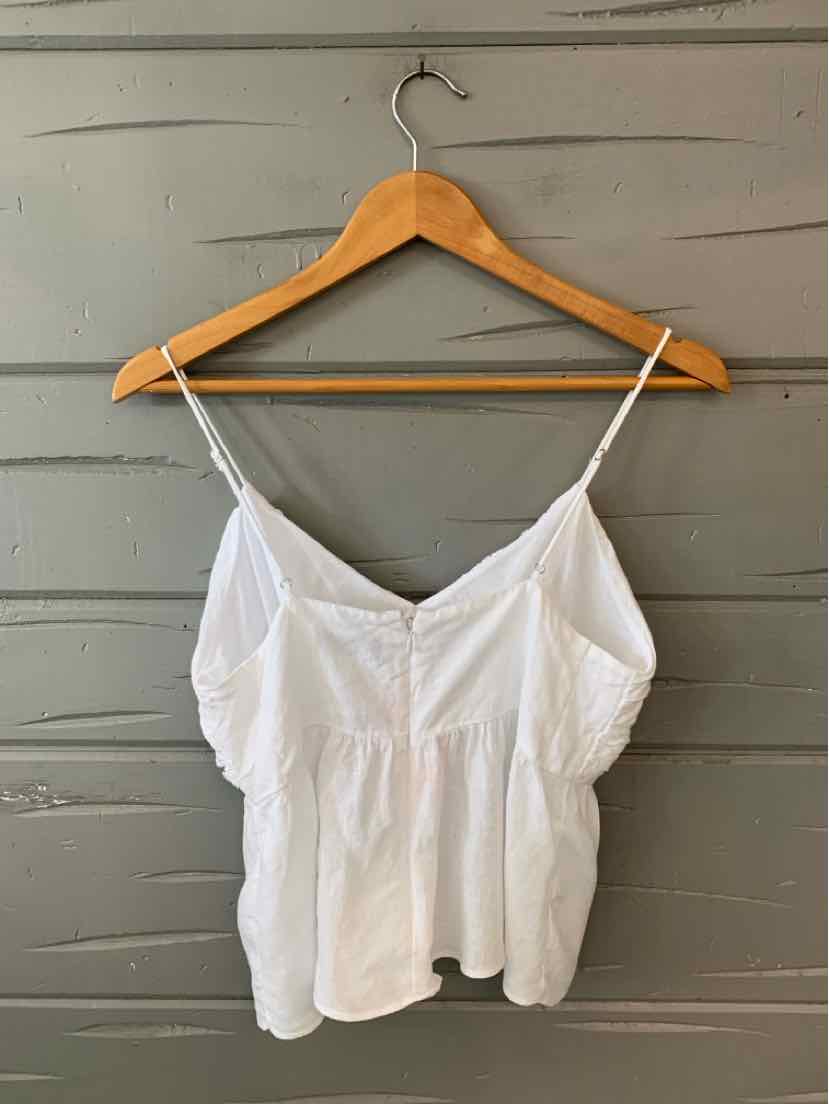 White sleeveless blouse with thin spaghetti straps and a gathered waist detail.