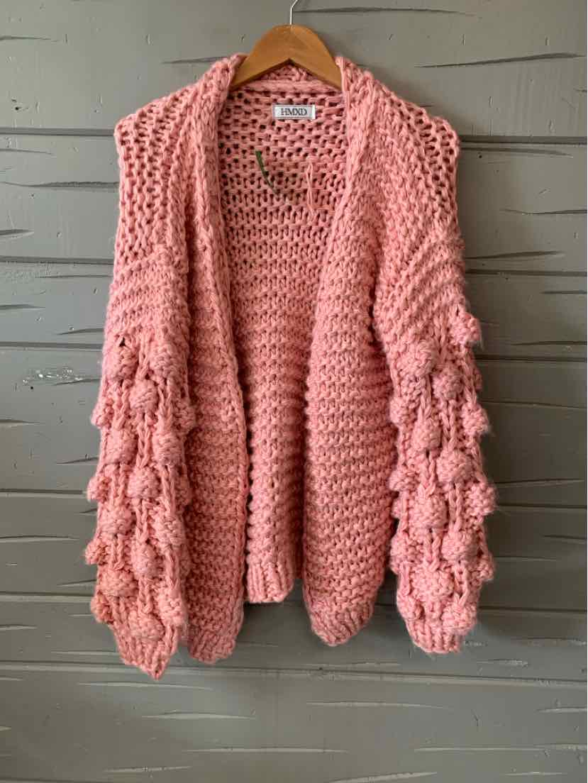 Chunky knit cardigan in soft pink with textured bobble sleeves and open front design.