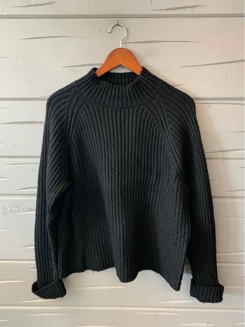 Black ribbed knit sweater with a high crew neckline, long sleeves, and a relaxed fit.