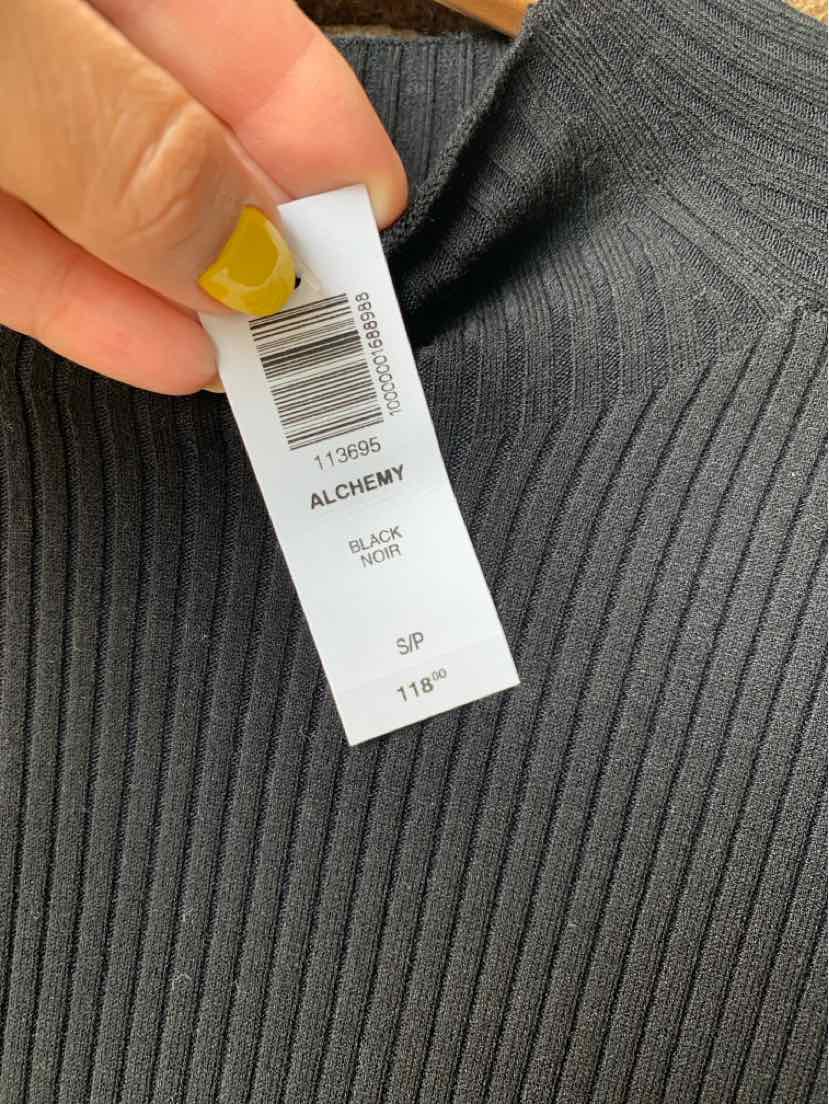 Black ribbed knit fabric close-up with size small tag held by hand with yellow nail polish.