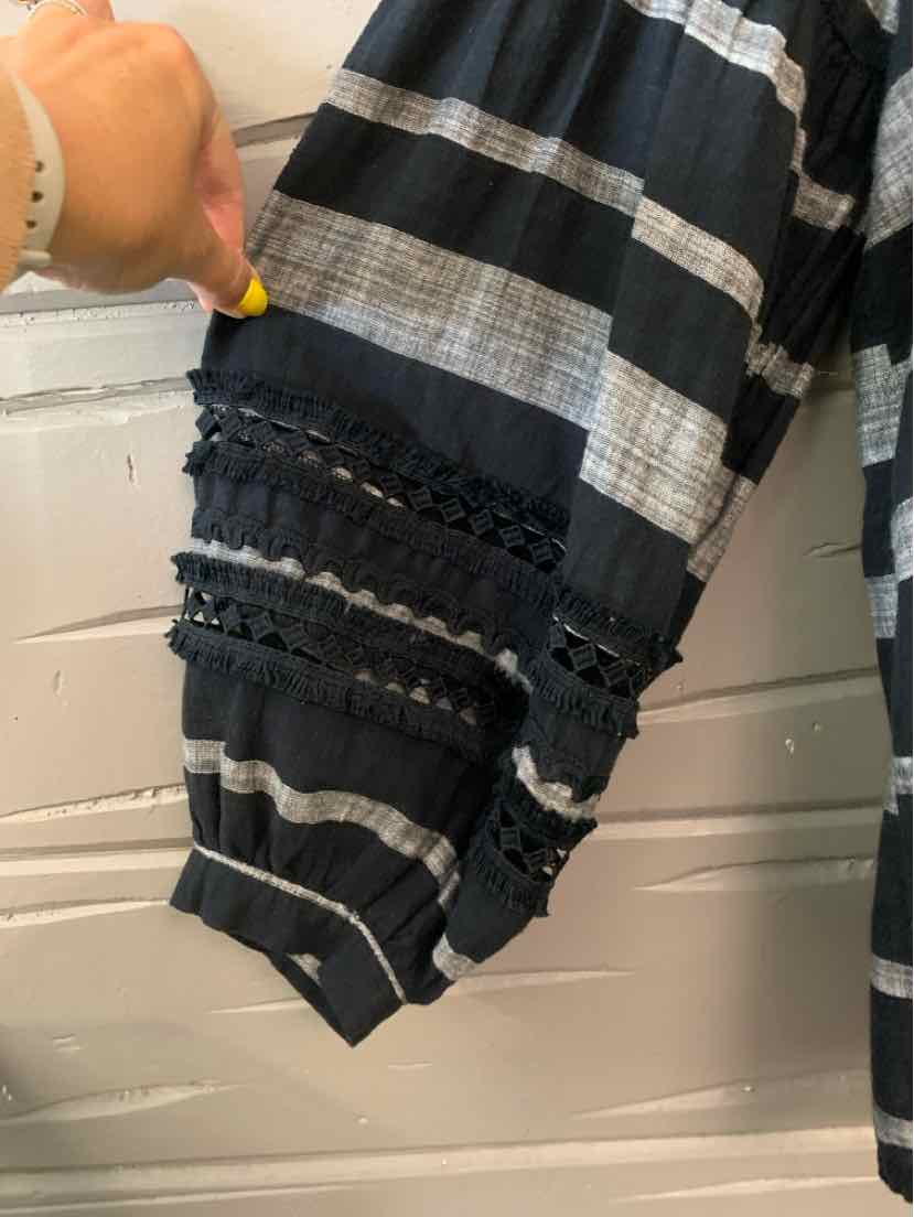 Black and white striped sleeve with lace and ruffle trim details on lightweight fabric.