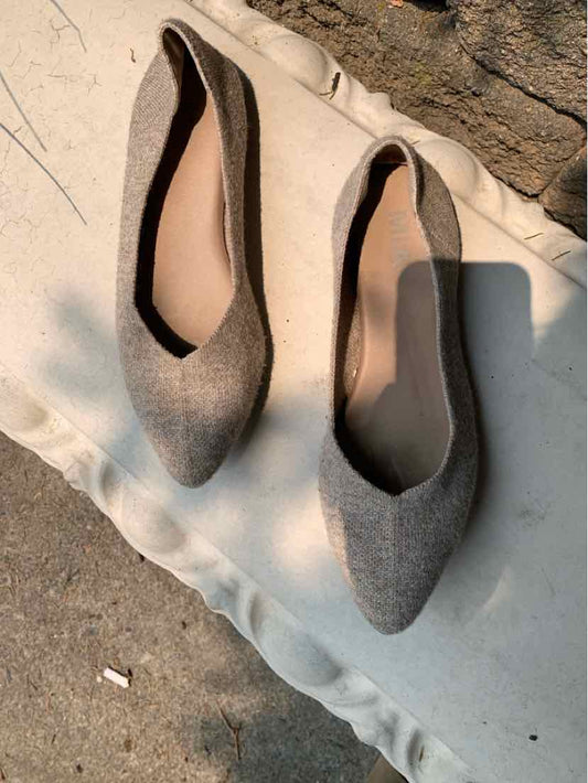 Pair of beige pointed-toe flats with a smooth fabric texture and low-cut sides, size 10.